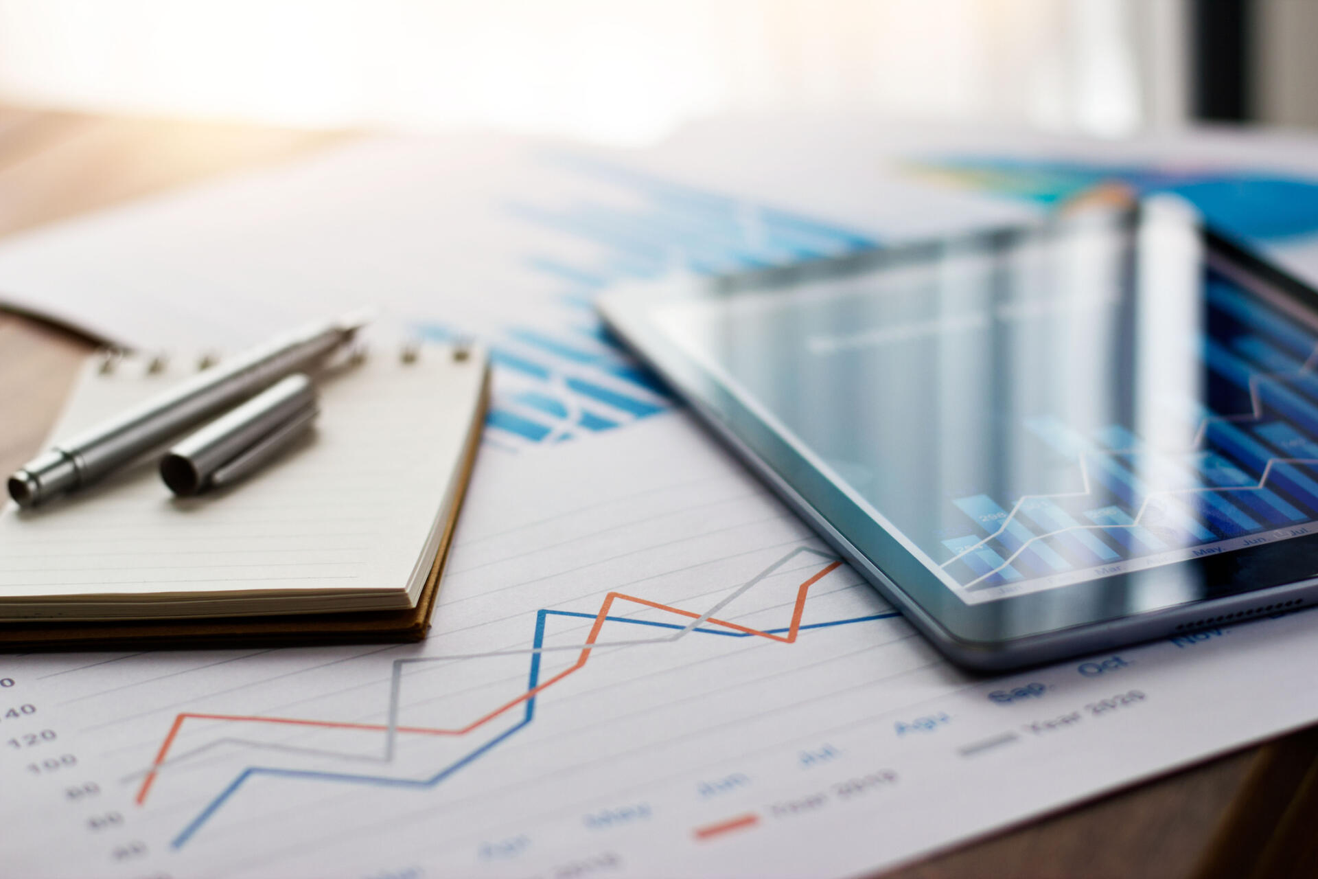 Tablet and notepad showing graphs