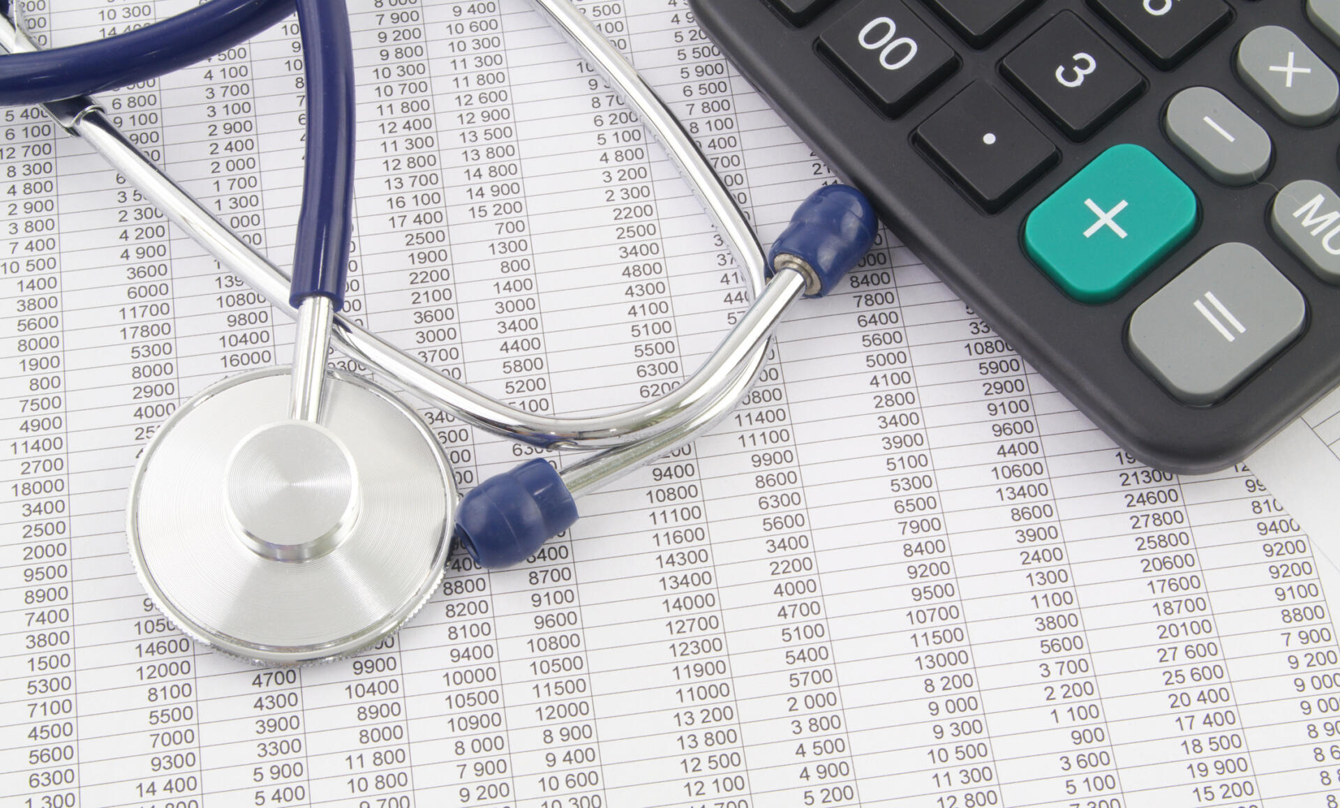 Calculator, stethoscope and printed financial reports