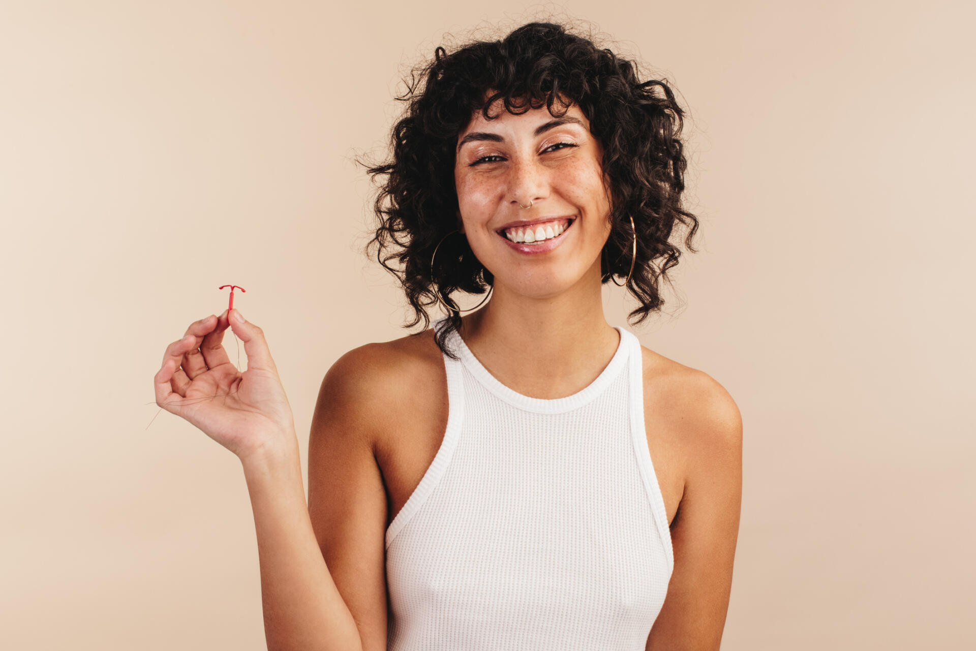 Happy woman holding a copper IUD
